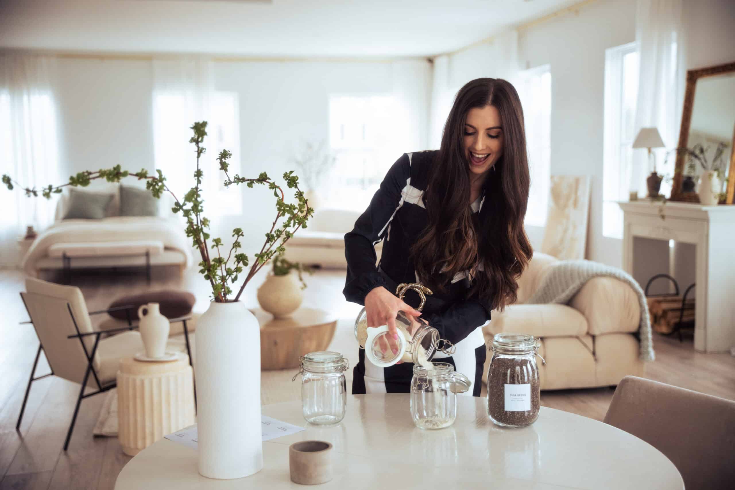 Caitlin Ruth V professional organizer, Interior Designer and business owner demonstrating decanting rice into a jar in a beautifully organized home